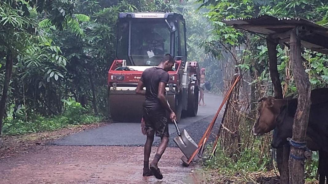 বৃষ্টির মধ্যেই সড়কে পিচ ঢালাই
